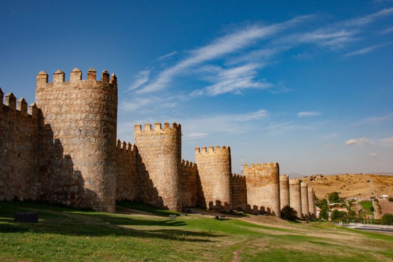 Explore the historic stone walls of Ávila on a sunny day in Spain.