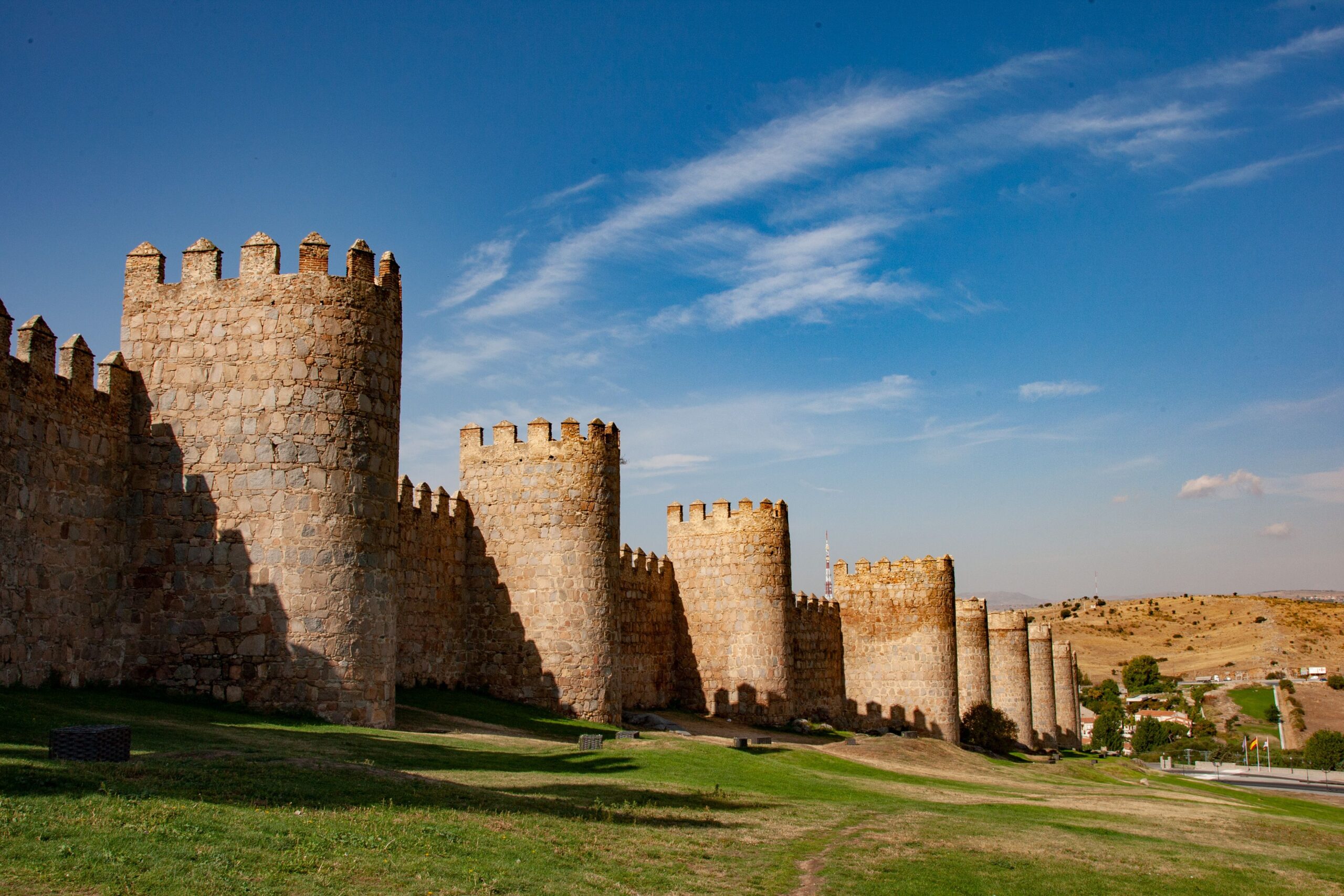 Explore the historic stone walls of Ávila on a sunny day in Spain.